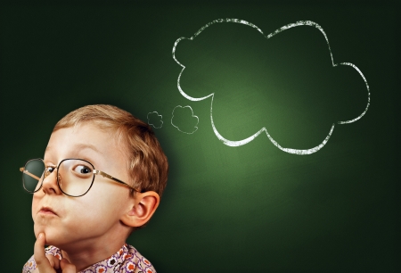 Thoughtful boy funny portait with abstract idea clouds on chalkboardの写真素材