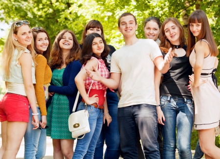 Group of flirting young girls with happy smiling popular boyの写真素材