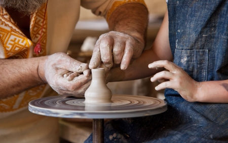 Closeup image potter man and child hands making a vaseの写真素材