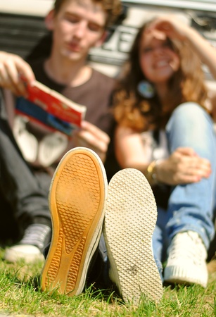 Closeup image sneakers of young couple sitting near the carの写真素材