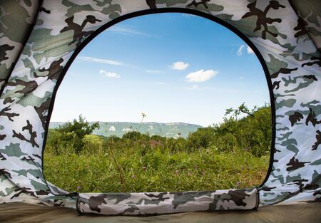 Closeup image open door in tourist tent with view on mountain landscapeの写真素材