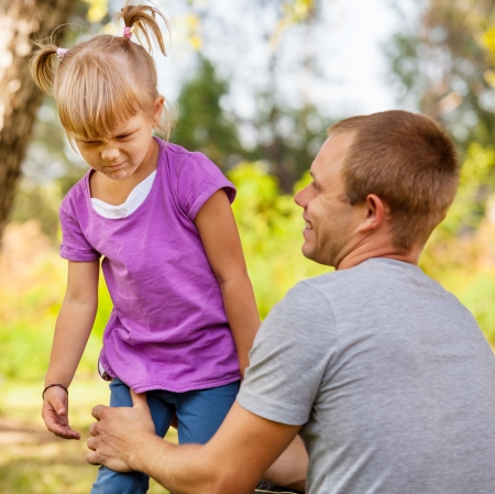 Father talking with cranky little daughterの写真素材