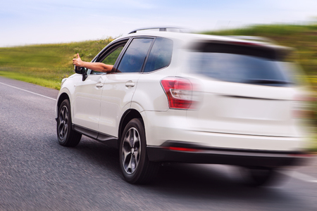 New car Happy owner rides the highway and shows thumb upの写真素材