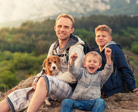 Active leisure - father with sons on mountain walkの写真素材