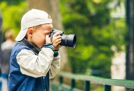 Little boy with photo camera makes a shootの写真素材