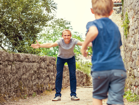 Son runs  to his father hugsの写真素材