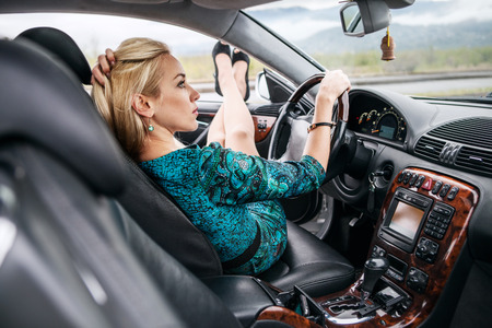 Beautiful young woman sitting in carの写真素材
