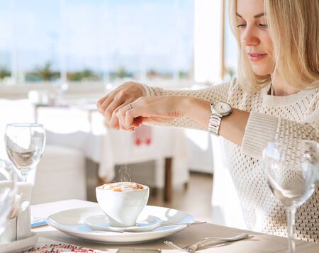 Young lady added sugar in coffeの写真素材
