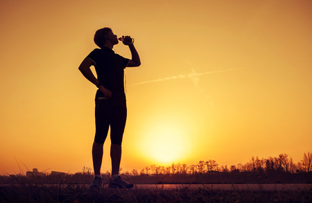 Runner drinks water after trainingの写真素材