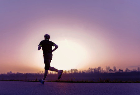 Running man silhouette in sunset timeの写真素材