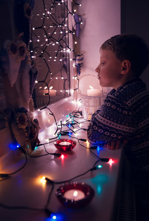 Waiting boy portrait in Christmas lightsの写真素材
