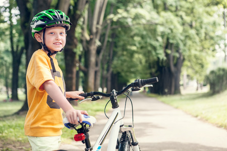 Smiling boy with new bicycle in parkの写真素材