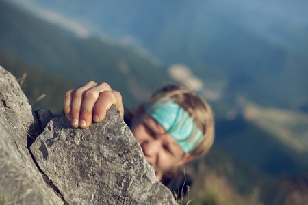 Young man finishing his extreme mountain climbの写真素材