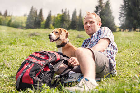 Man with his dog rest on the mountain hillの写真素材