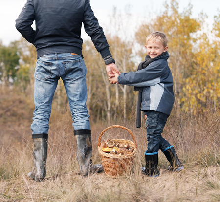 Smiling little boy with a his father on the mushroom pickingの写真素材