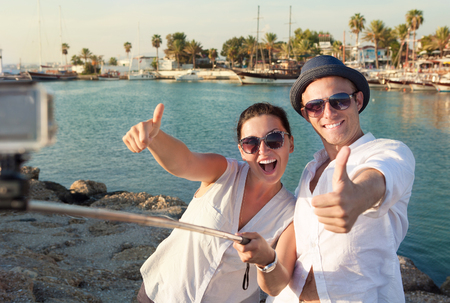 Positive young couple take a selfie photo in tropical harborの写真素材