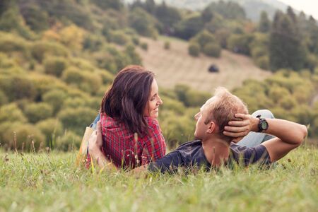 Loving couple tender conversation at the green meadow in country sideの写真素材