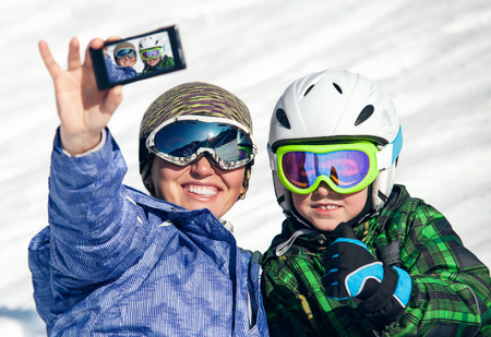 Mother and son take a selfie photo on ski resortの写真素材