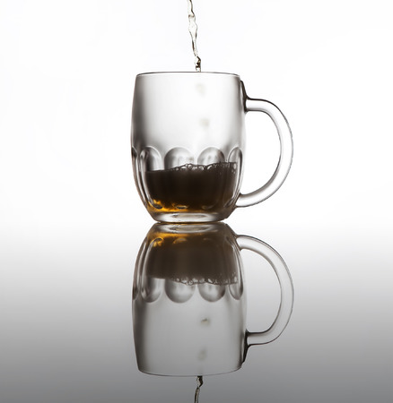 Iced beer mug on the glass surfaceの写真素材