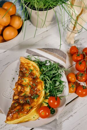 Omelet with ruccols and cherry tomatoesの写真素材