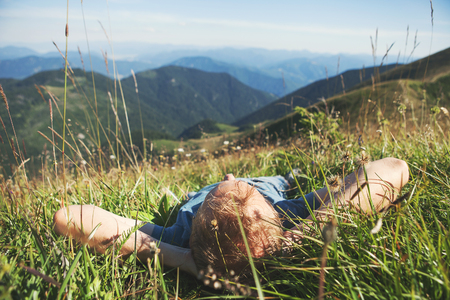 Man lying in high green grass on the mountain medaowの写真素材