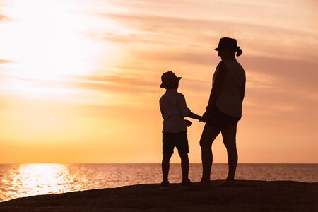 Mother and son silhouettes at the sunset timeの写真素材