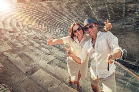 Positive young couple take selfie photo in Side antique amphitheaterの写真素材
