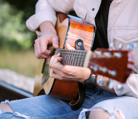 Man hands on the guitar strings close up imageの写真素材