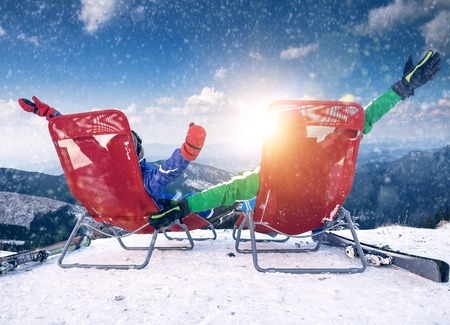 Two happy skiers on the top of mountainの写真素材