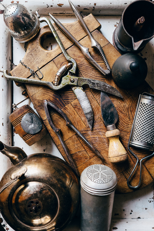 Old kitchen props : Nutcrackers, knives, kettle etc on the vintage cutting boardの写真素材
