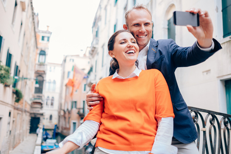 Happy smiling couple take a selfie photo on the old Venice streetの写真素材