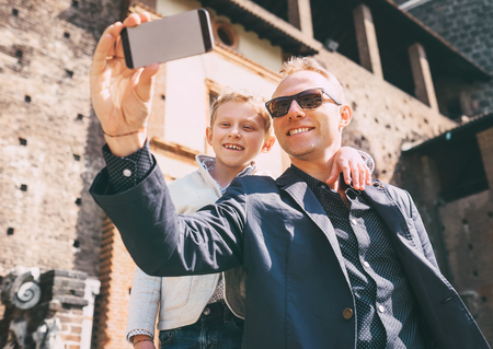 Father with son take a selfie photo in old castleの写真素材