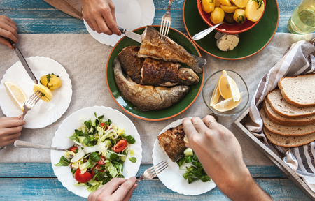 Dinner with fried fish, potatoes and fresh salad