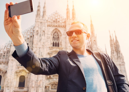 Man take a selfie photo on Duomo di Milano backgroundの写真素材