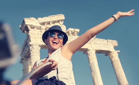 Happy smiling young woman take a selfie photo on antique sights viewの写真素材