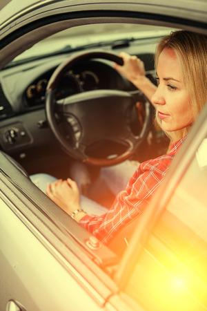 Beautiful young woman sitting in carの写真素材