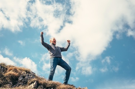 Triumphed man on the top of mountain peakの写真素材