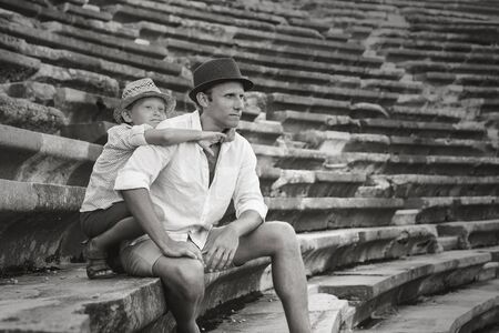 Father with son sitting on antique amfitheater steps. Side, Turkeyの写真素材