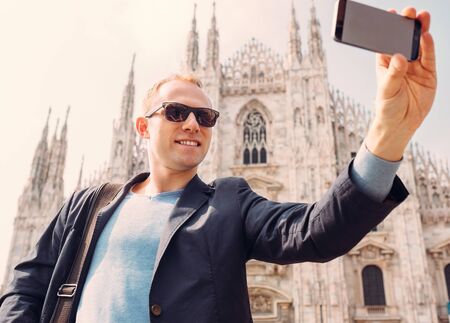 Man take a selfie photo on Duomo di Milano backgroundの写真素材