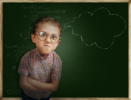 Emotional pupil boy near chalkboardの写真素材