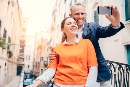 Happy smiling couple take a selfie photo on the old Venice streetの写真素材