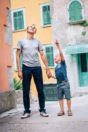 Father with son walk together on the old sity streetの写真素材