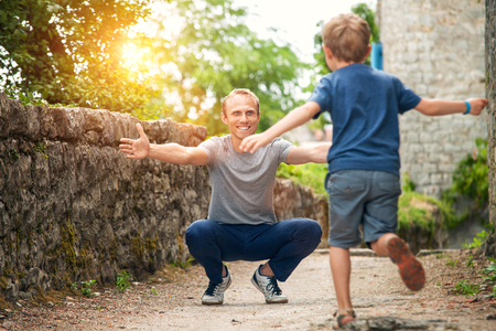 Son runs to his father hugsの写真素材