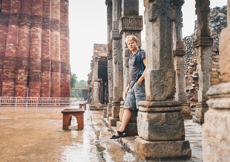Indian monsoon season - young tourist man waits intense rain in Qutb Minar, New Delhiの写真素材