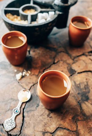 Ginger tea in clay cups  and rustic sugar-bowl on the wooden tableの写真素材