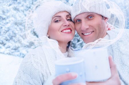 Couple in love in snow forest with heart frame from steamの写真素材