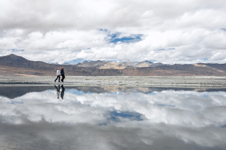Two travelers walks near Tso Kar Lake in Himalaya Mountainの写真素材