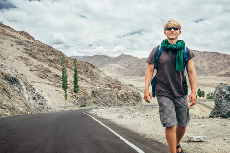 Traveler walks on the mountain road in indian Himalayaの写真素材
