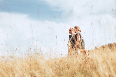 Two positive tourist mans walks on golden fieldの写真素材