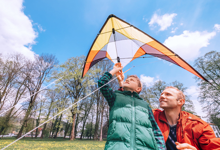 Father with son start to fly a kiteの写真素材
